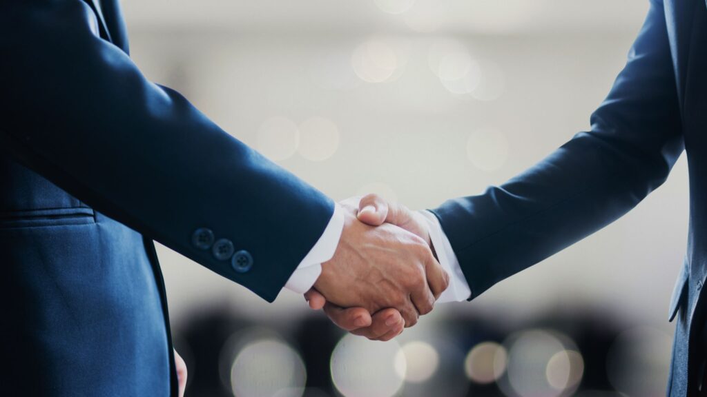 two men shaking hands to depict partnership of Juno Rocket and Tullup